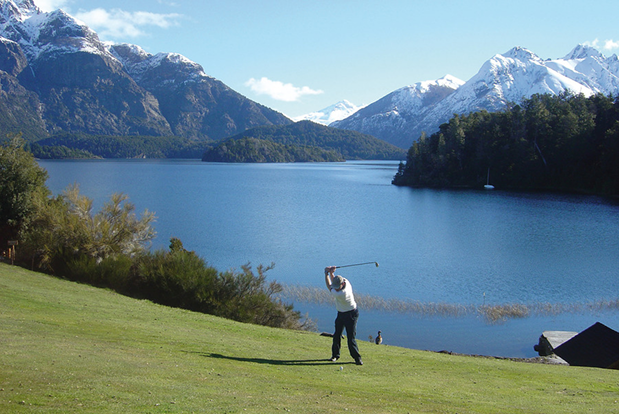Jugador de golf en el campo del Llao Llao con el lago y los Andes de fondo
